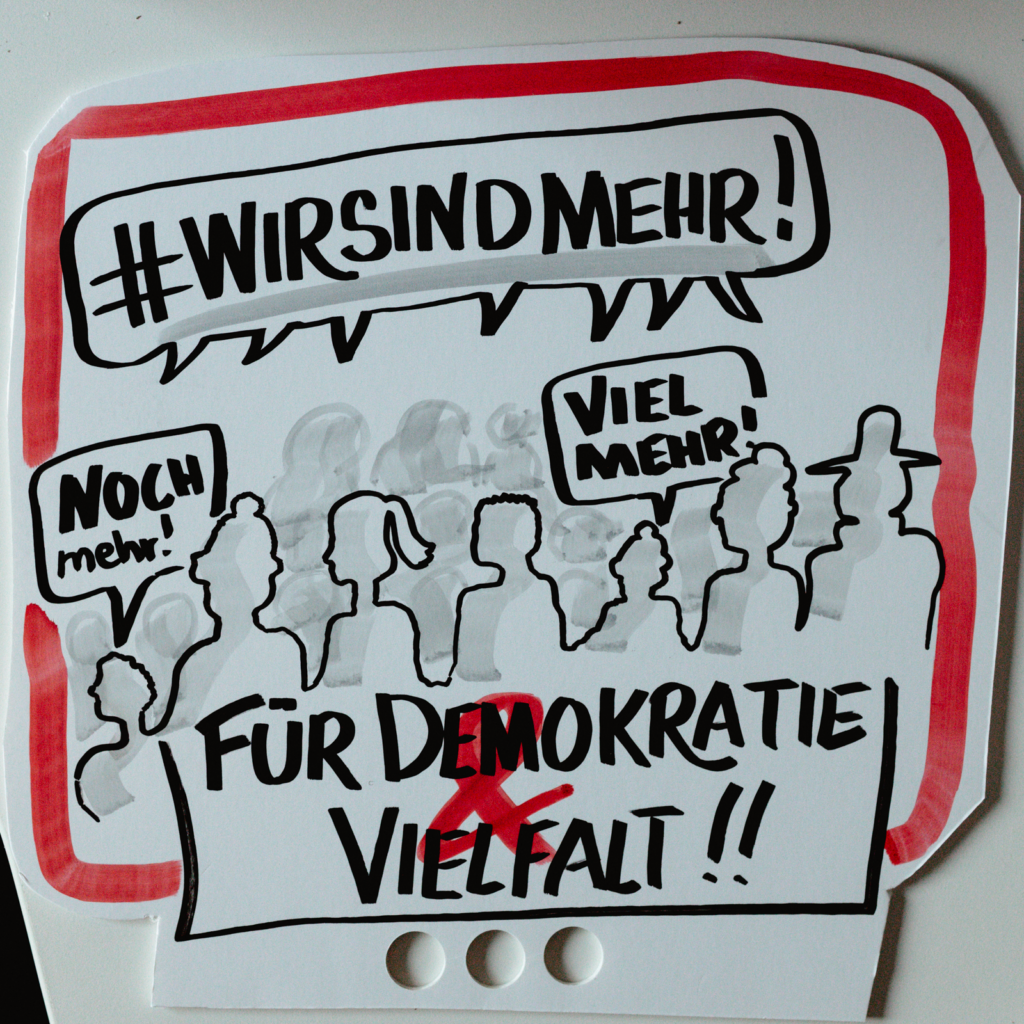 Sandra Dirks - Beispiel für ein Kundgebungsschild mit der Aufschrift "Wir sind mehr! - Viel mehr"