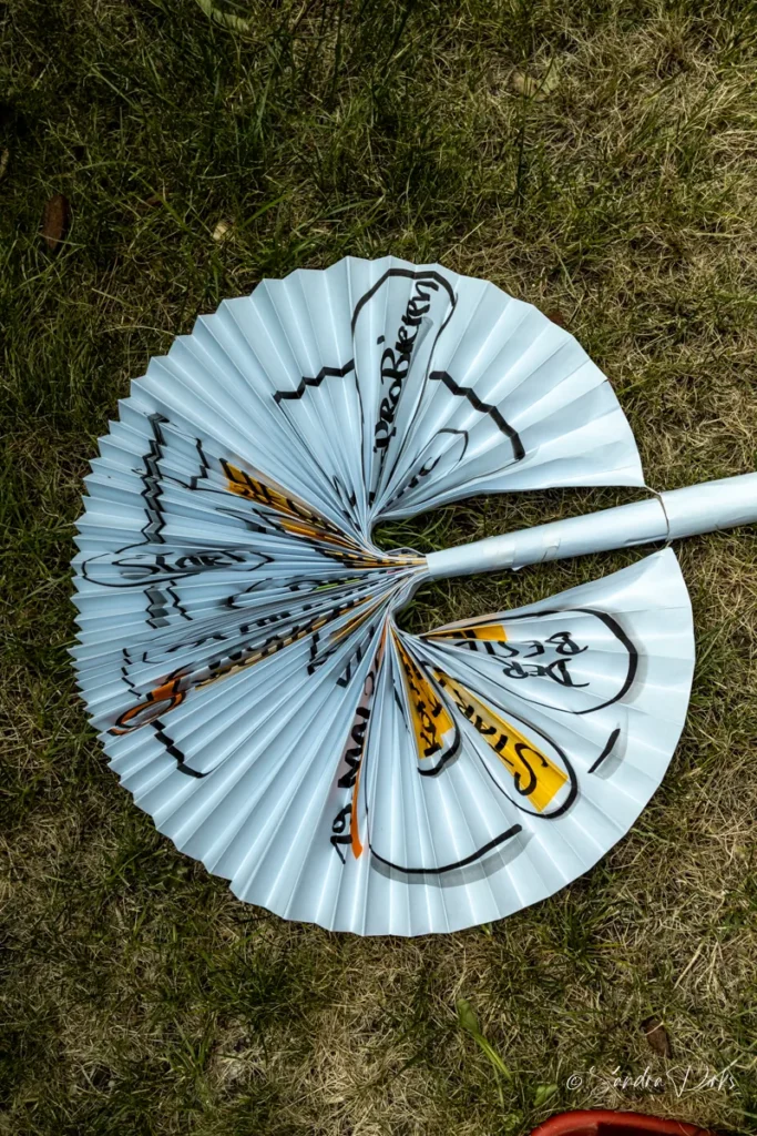 Flipchart-Sonnenschirm mit Papierrollen-Stiel, hochkant auf der Wiese liegend
